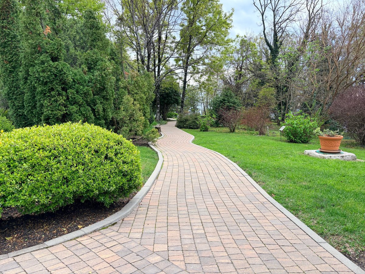 The pathway in a well-maintained park, path is paved with light brown interlocking bricks