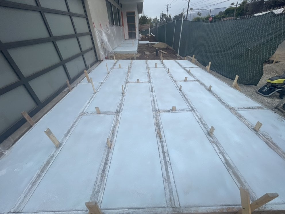 White roof panels with metal reinforcement strips laid out on a residential structure during installation
