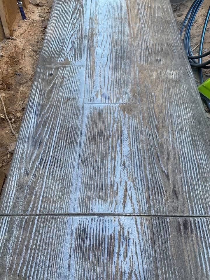 Wooden deck boards with weathered gray finish and blue paint accent stripe down the center on outdoor ground